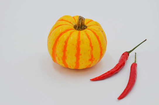 白色背景上的小南瓜和紅辣椒
