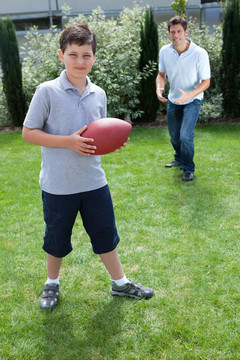 小男孩和爸爸玩美式足球