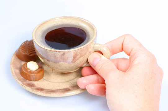 果仁巧克力；杯；黑咖啡和女性手上白色
