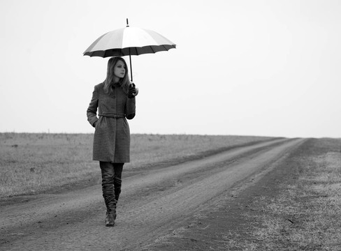 鄉(xiāng)村路帶雨傘的寂寞女孩。