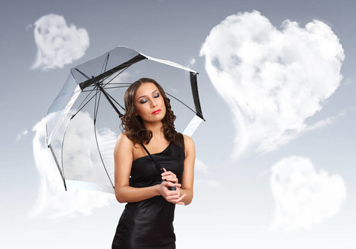 漂亮的年輕女人帶著雨傘和心