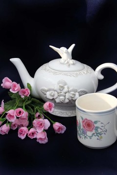 帶玫瑰花的茶壺和熱茶杯