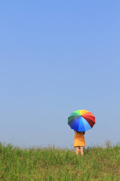 美麗的女人拿著五顏六色的傘和藍(lán)色的天空