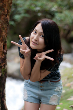 亞洲泰國(guó)美女站在瀑布的樹(shù)上