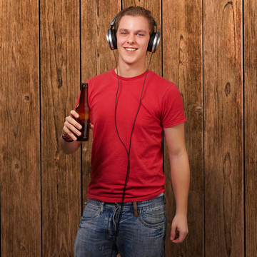年輕人聽音樂和手持啤酒的肖像