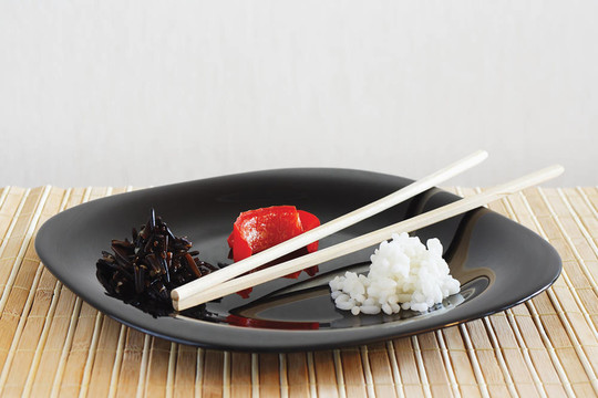 盤子上有白色和黑色的上升和甜胡椒在竹桌布仍然生活