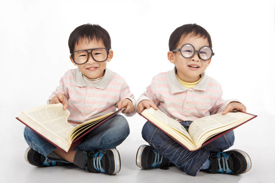 快樂的孩子戴著黑色眼鏡的大書