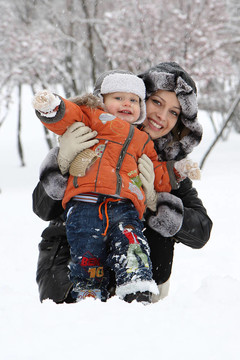 年輕的媽媽和她的兒子在雪中
