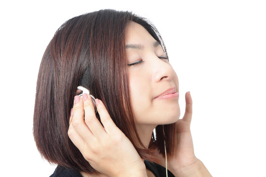 年輕女孩聽音樂，閉上眼睛