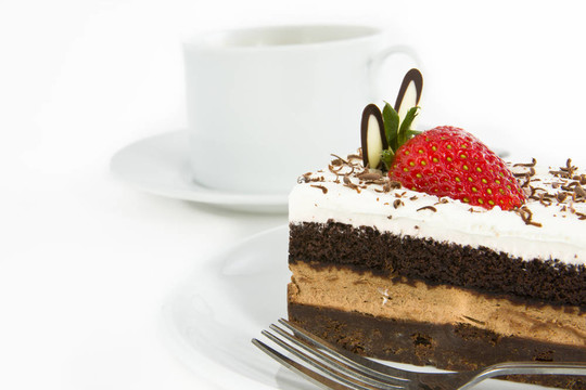 一块巧克力蛋糕与草莓装饰顶部和杯子