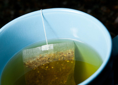 綠茶在熱水中沖泡的藍(lán)色杯
