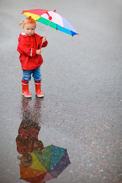 雨天帶著五顏六色雨傘的小女孩
