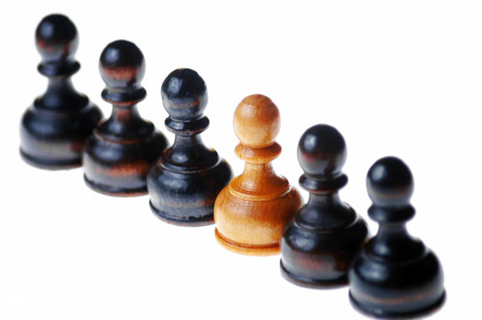 白色的棋子站在一排黑色的棋子；白色隔離；選擇性聚焦