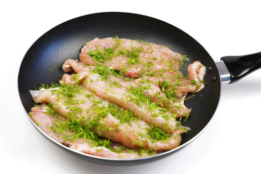 在煎鍋上準(zhǔn)備油炸的生雞肉