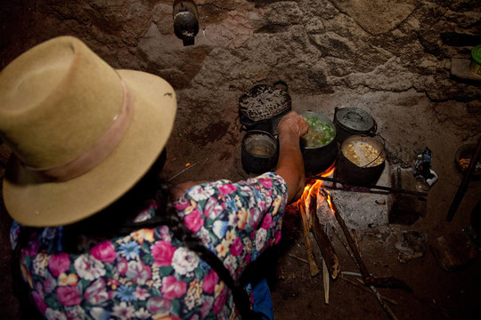 女人在秘魯安第斯山脈的小屋里做飯