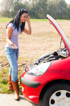 女人在她的車(chē)拋錨了。發(fā)動(dòng)機(jī)故障