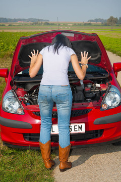 女人在她的車拋錨了。發(fā)動機(jī)故障