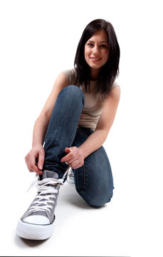 年輕女子綁著球鞋和微笑