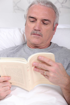 成熟男人在床上看書