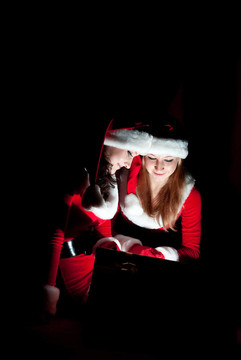 兩位女性在Santa服裝店開啟圣誕禮物。