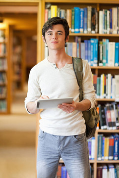 一位面带微笑的学生拿着平板电脑的肖像