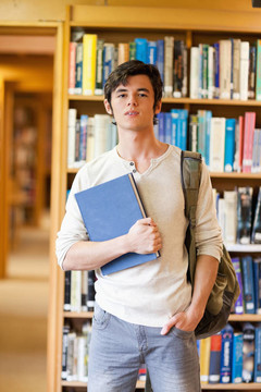 微笑的學(xué)生在書中擺姿勢