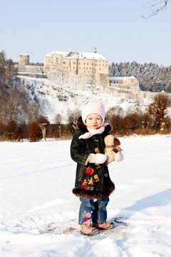 站在冬天里的小女孩和Cesky Sternberk Castle在捷克共和國的背景；