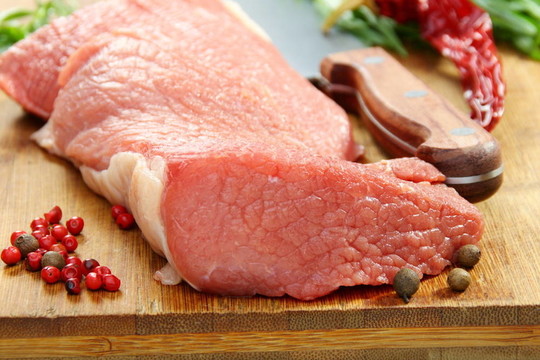 新鮮肉和香料在廚房板上。