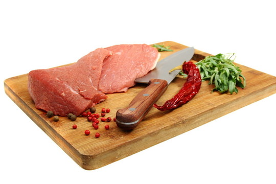新鮮肉和香料在廚房板上。