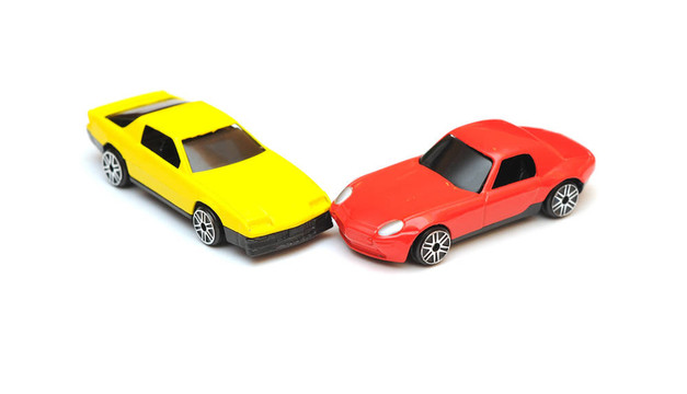 玩具車事故。汽車碰撞白色孤立