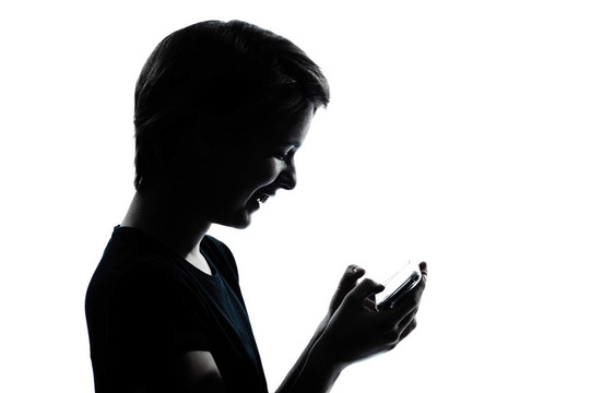 一個(gè)白人少年剪影的男孩或女孩的可視電話的視頻游戲的肖像工作室把孤立在白色背景