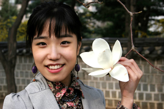 漂亮的韓國女人拿著一朵花