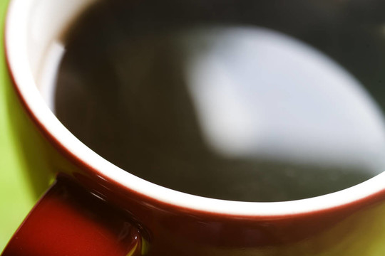 綠色背景上的紅色咖啡杯