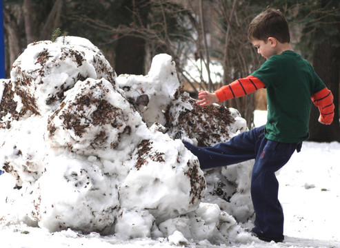 小男孩踢雪