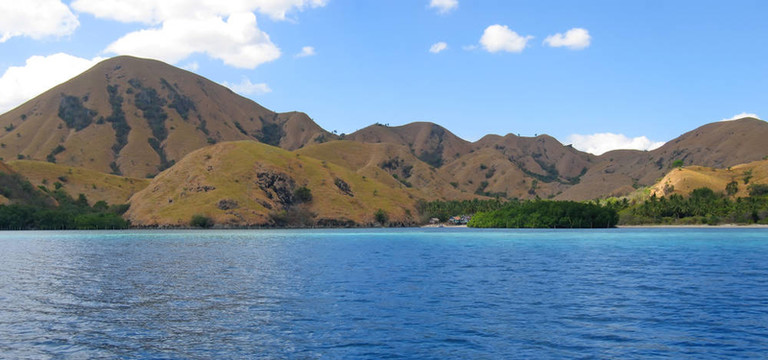 黃色的山落在科莫多島海；印度尼西亞；全景