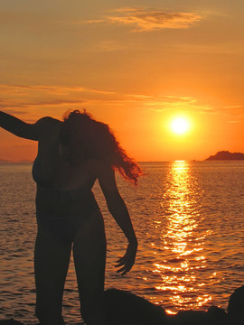 夕陽的運動中的女人；納閩下；有沙灘；弗洛里斯島；印度尼西亞