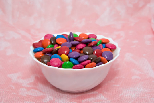 在粉紅色的背景Smarties碗