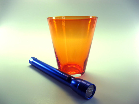 橙色飲用玻璃和手電筒