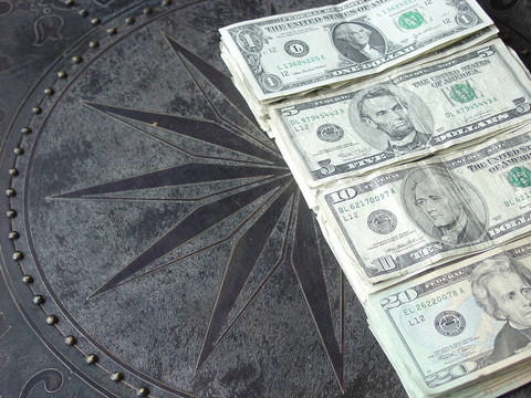 現(xiàn)金散布在一個有圖案的青銅臺面
