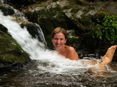笑的女孩沐浴在森林瀑布