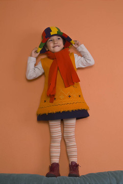 在橙色的帽子打衣服的小女孩