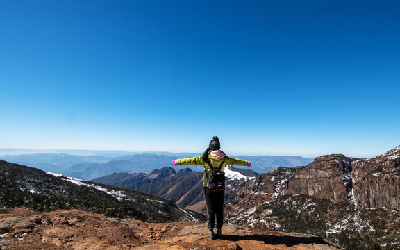 站在雪山懸崖峭壁上的少女
