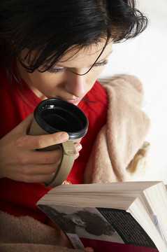 年輕美麗的女人正在讀一本書