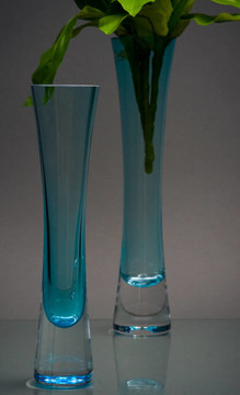 兩個(gè)藍(lán)色的玻璃花瓶，灰色的綠色花束