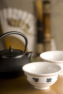 中國(guó)茶壺；兩杯；桌上的扇子和竹子