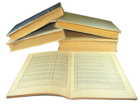 舊的黃色書(shū)籍與數(shù)學(xué)表孤立在白色