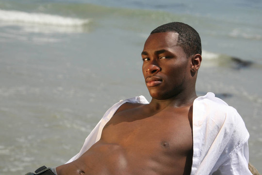 英俊的非洲裔男子在海灘上裸露的胸部