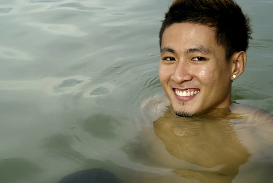 微笑的亞洲男子在海上