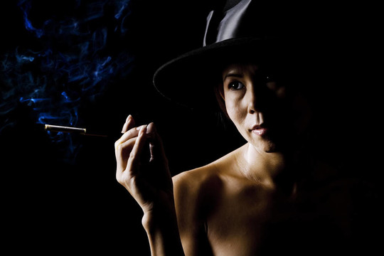 戴著黑色帽子戴著香煙的女人