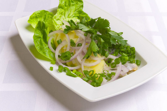 土豆加鯡魚；白盤子上的洋蔥和歐芹